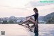 A woman sitting on the edge of a swimming pool.