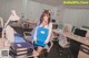 A woman sitting at a desk in an office holding a folder.