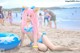 A woman in a bikini sitting on the beach.