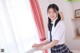 A young woman in a school uniform standing by a window.