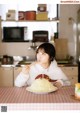 A woman sitting at a table eating a plate of food.