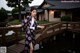 A woman in a kimono standing on a wooden bridge.